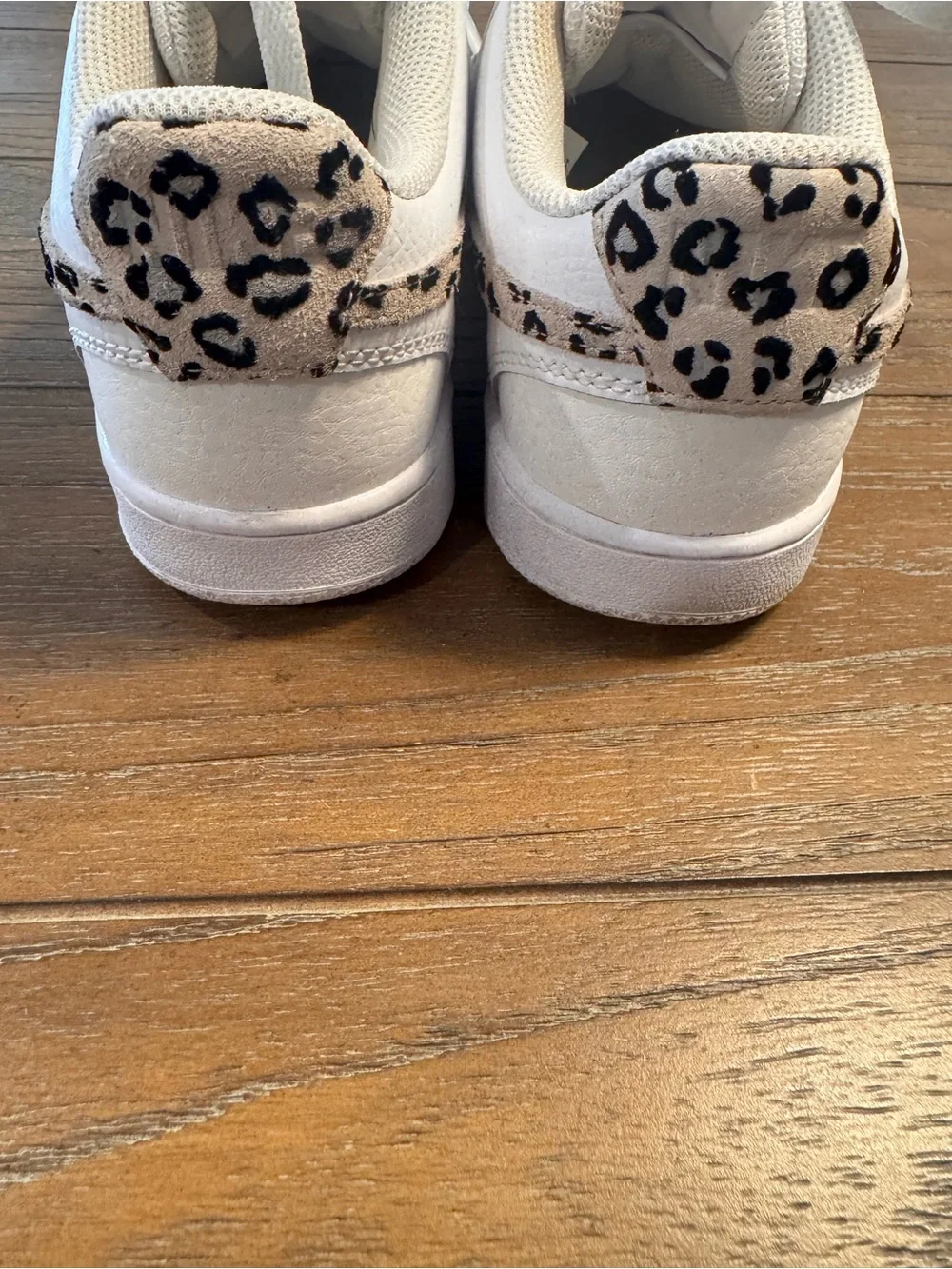 Nike White Low-Top Sneakers with Black Swoosh and Leopard Detail